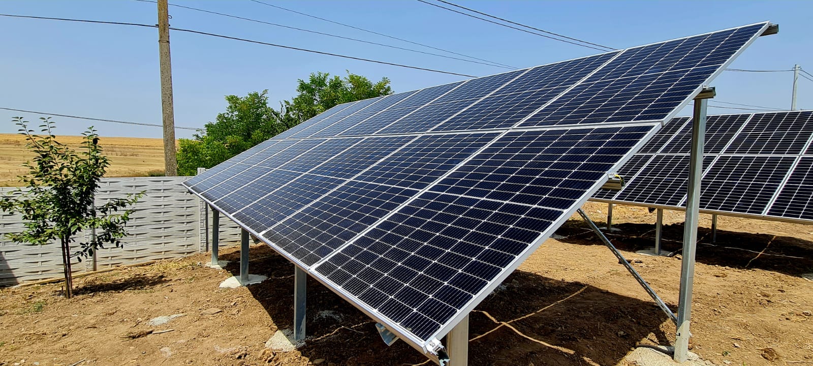 Panouri fotovoltaice ground-mount în curte cu împrejmuire